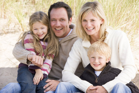 坐在沙滩上微笑的一家人图片