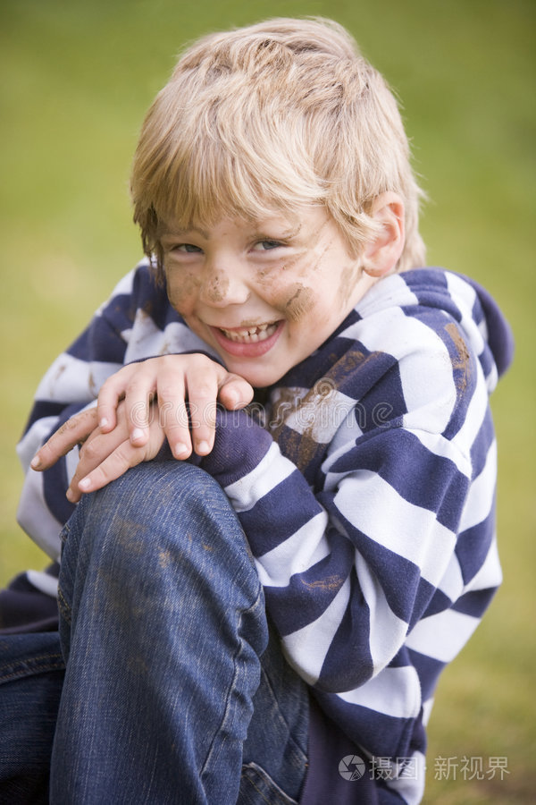 坐在户外脏兮兮的小男孩