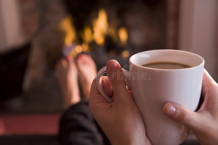 用咖啡在壁炉前暖脚