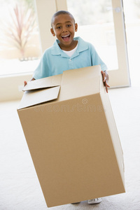 抱着盒子在新家微笑的小男孩