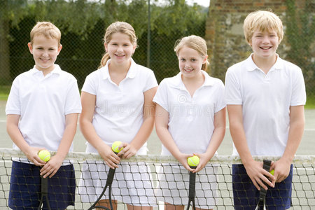 网球场上的四个年轻朋友微笑着