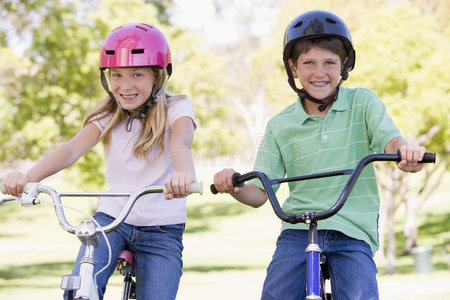 兄弟姐妹在户外骑自行车微笑