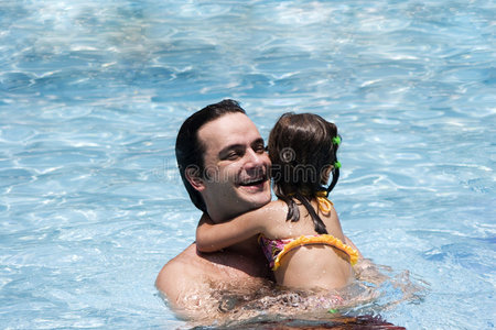 爸爸和女儿在游泳池里