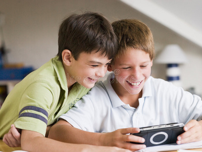 两个小男孩玩手持式电子游戏
