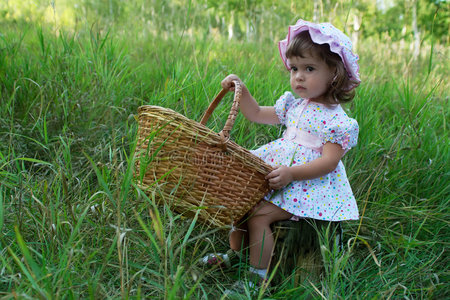 坐在树桩上拿着篮子的小女孩