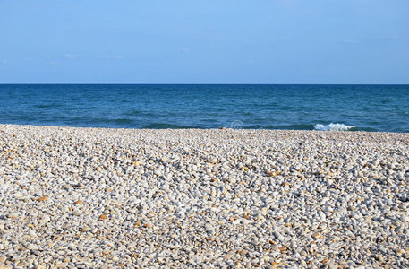 可爱的小女孩在鹅卵石海滩上玩石头海在海滩上的卵石在波罗的海岸边