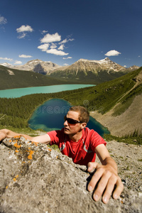 年轻的登山者在山上伸手抓住