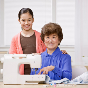 孙女和祖母用缝纫机