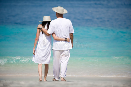 在海滩上戴帽子的浪漫夫妇图片