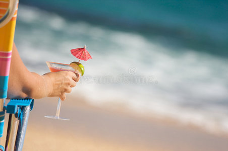 带着热带饮料的海滩上的女人