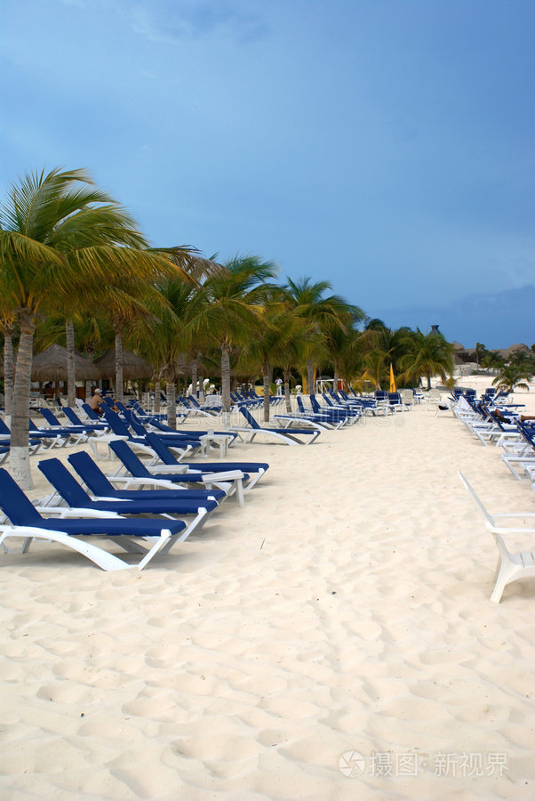 的美丽日落克里特岛特里奥佩特拉海滩沙滩上的床和伞热带海滩上的床和