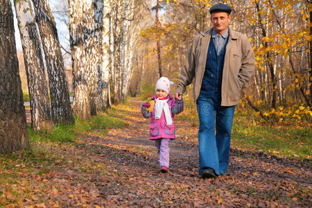 爷爷带着孙女在公园散步