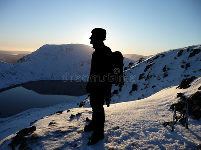 雪山山顶上的登山者剪影图片