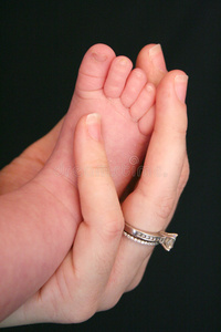 刚出生的婴儿手和脚印孩子在洗脸盆里洗手和洗脚母亲的手和婴儿的脚