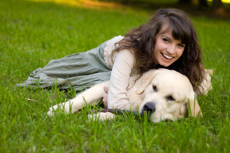 草地上养狗的女孩家庭与狗所有者的女人训练金毛狗在草地上,给爪子