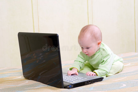 在笔记本电脑上工作的女婴