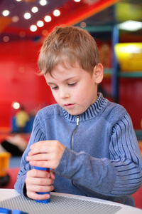 小男孩在幼儿园和建设者玩耍