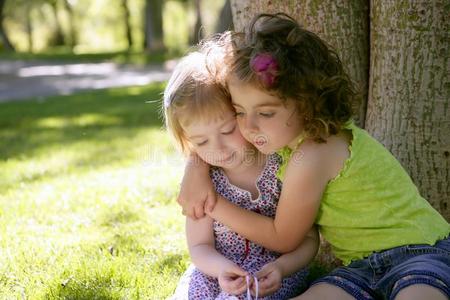 两个妹妹抱在树下玩耍