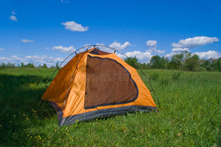 绿色草坪上的旅游黄帐篷