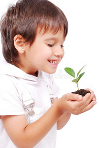 小可爱的孩子手里拿着绿色的植物