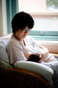 靠窗母乳喂养新生儿照片