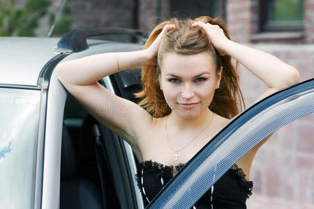 年轻快乐的女人靠近车。