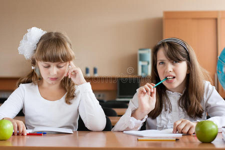 两个女孩坐在课桌旁
