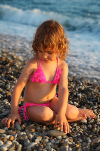 小女孩坐在沙滩上