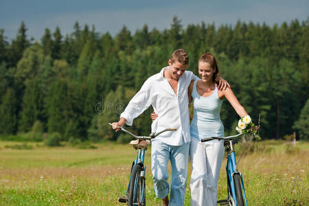 夏季在草地上骑自行车的浪漫情侣
