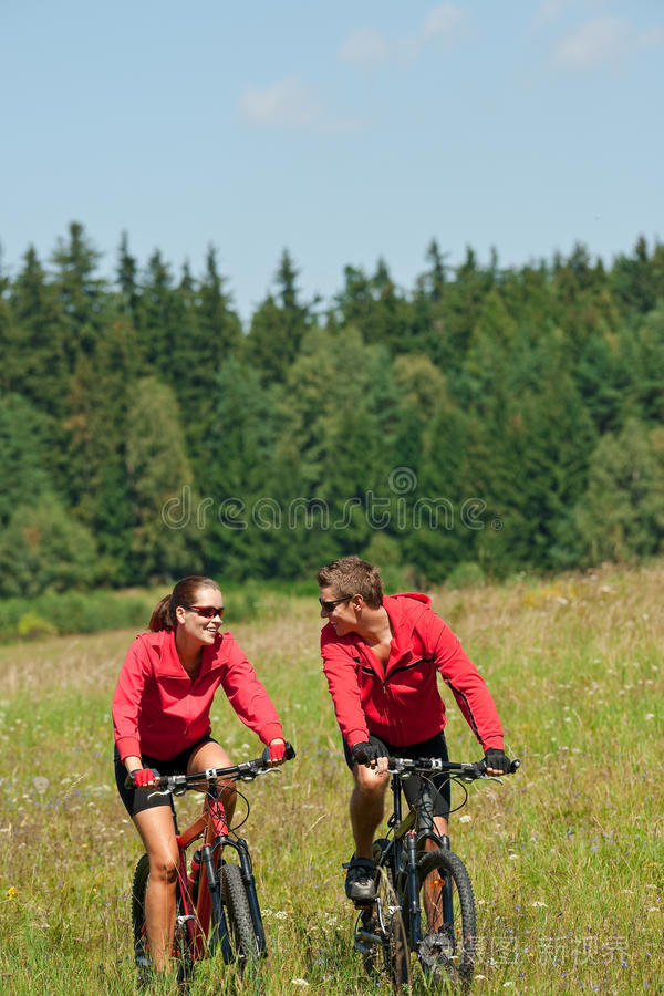 夏季自行车草地上的年轻运动情侣