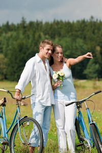 夏季在草地上骑自行车的浪漫情侣