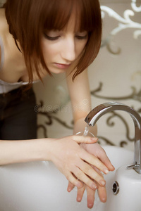 年轻的女人在洗脸