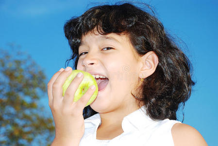 非常可爱的女孩在户外吃苹果