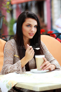 在户外咖啡馆喝茶的女人