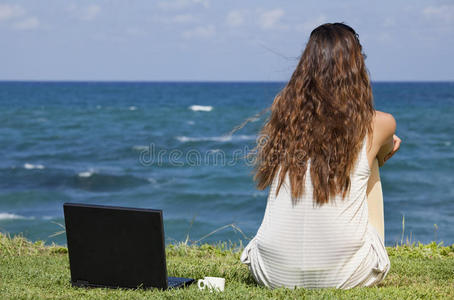 海滩上拿着笔记本电脑的女人