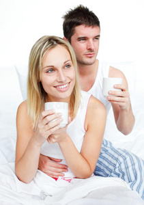 穿着睡衣在床上喝咖啡的夫妇