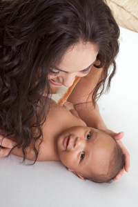 拉丁裔母亲在床上和她的男婴玩耍