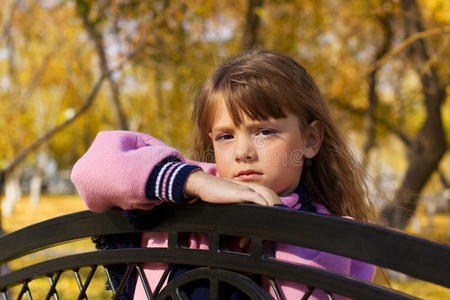 坐在长凳上的小女孩。