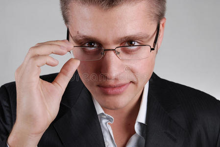 年轻的商人碰他的眼镜