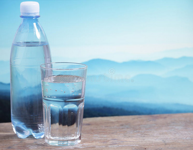薄荷苏打水矿泉水矿泉水倒入玻璃矿泉水瓶矿泉水蓝色背景上的矿泉水女