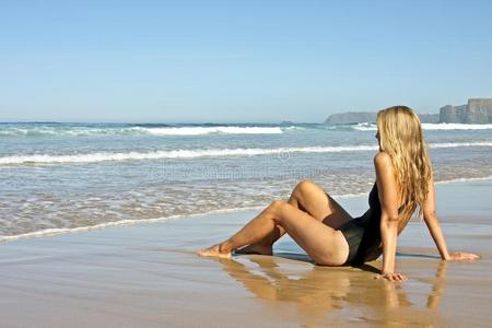 年轻的金发女郎在海滩上放松