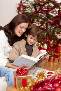 带着儿子的年轻母亲在圣诞节读书