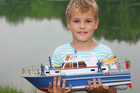 手拿玩具船上岸的男孩