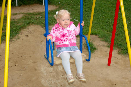 漂亮的小女孩在公园的操场上玩耍。