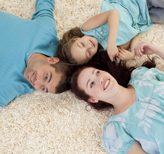 父母和女儿一起躺在地板上