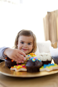 微笑的小女孩在家吃糖果图片