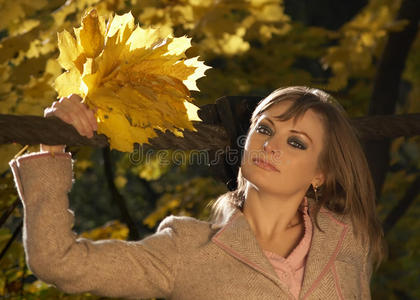 站在桥上拿着树叶的女人