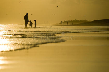 父亲和两个孩子在沙滩上玩耍