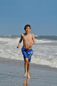 在海滩上跑步的小男孩