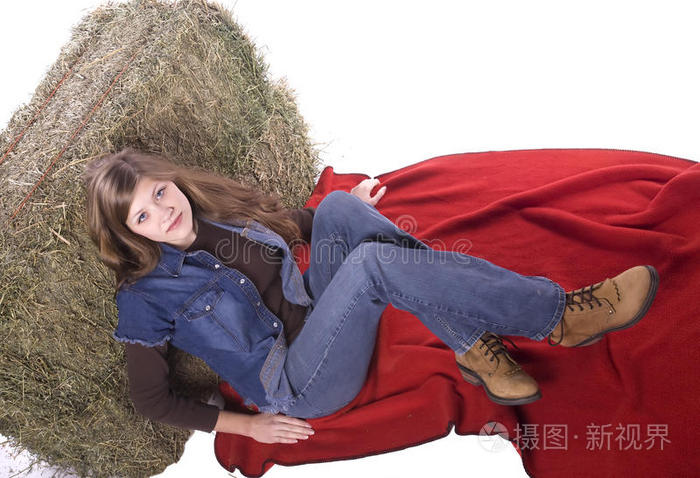 坐在毯子上靠着干草的女人